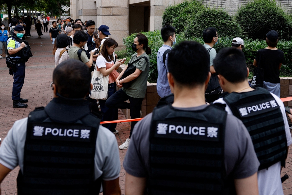 The public wait outside the West Kowloon Magistrates’ Courts building, before the verdict of the 47 pro-democracy activists, charged under the national security law, in Hong Kong. — Reuters pic