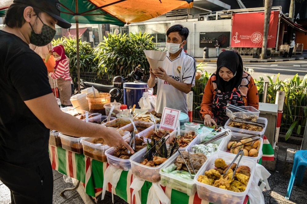 A street vendor selling nasi lemak and kuih at Bukit Bintang in Kuala Lumpur. According to TimeOut, nasi lemak is the top must-try cuisine in the country. ― Picture by Firdaus Latif