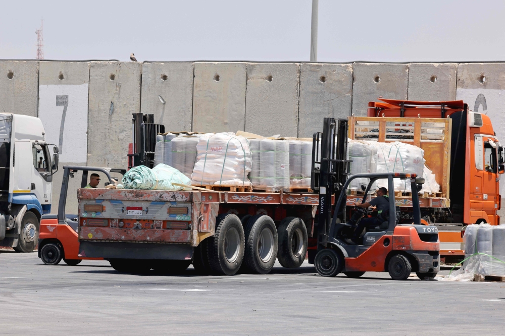 Workers load humanitarian aid for the Gaza Strip onto a truck at the Kerem Shalom (Karm Abu Salem) border crossing between southern Israel and Gaza, on May 30, 2024, amid the ongoing conflict in the Palestinian territory between Israel and Hamas. — AFP pic