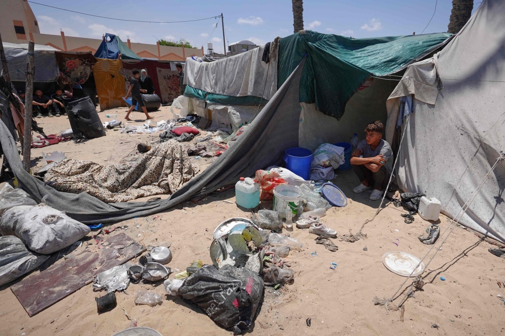 Displaced Palestinians sit by their tents at a makeshift displacement camp in Rafah's Mawasi area in the southern Gaza Strip May 29, 2024. — AFP pic
