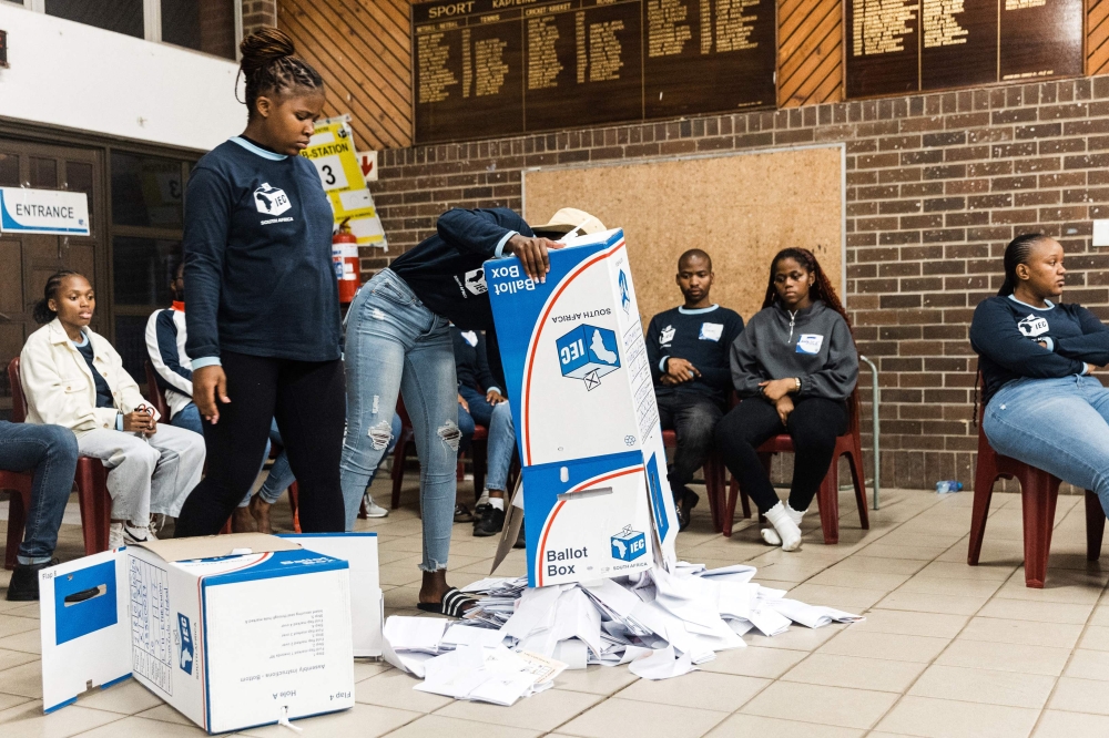 Electoral Commission of South Africa (IEC) officials empty a ballot box during the vote counting process at Addington Primary School voting station during South Africa’s general election in Durban on May 29, 2024. — AFP pic
