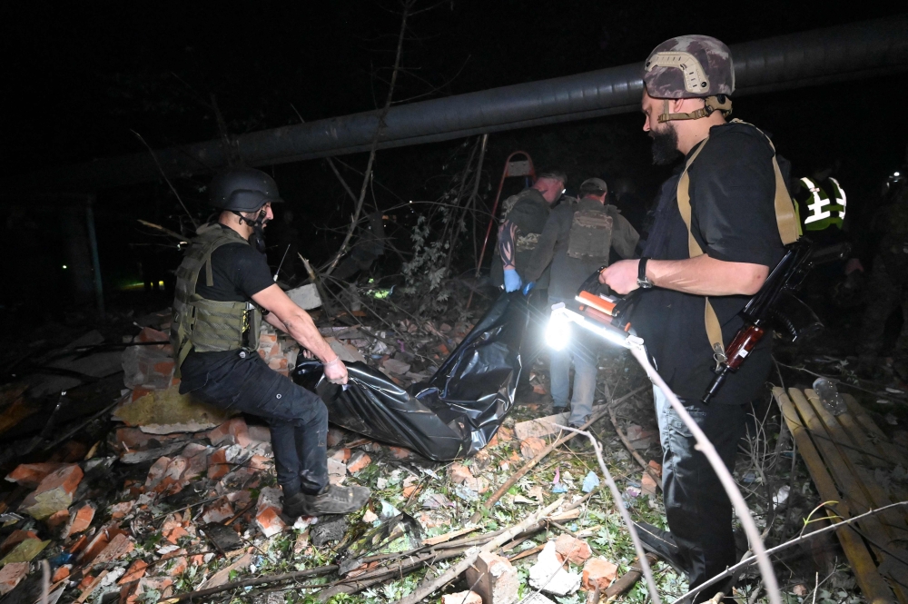 A police officer and volunteers carry a body out of the rubble of an apartment building hit by a Russian missile attack in Kharkiv early on May 31, 2024, amid the Russian invasion in Ukraine. — AFP pic