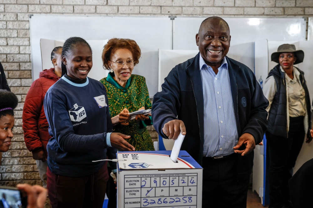 File photo of  President of the African National Congress (ANC) and South African President Cyril Ramaphosa (2nd right) reacting while casting his ballot at Hitekani Primary School polling station in Soweto on May 29, 2024, during South Africa’s general election. — AFP pic