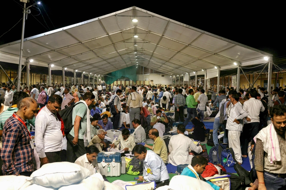 Polling officials gather to submit electronic voting machines (EVMs) and other polling materials at a collection centre in Varanasi on June 1, 2024, at the end of the seventh and final phase of voting in India's general election. — AFP pic