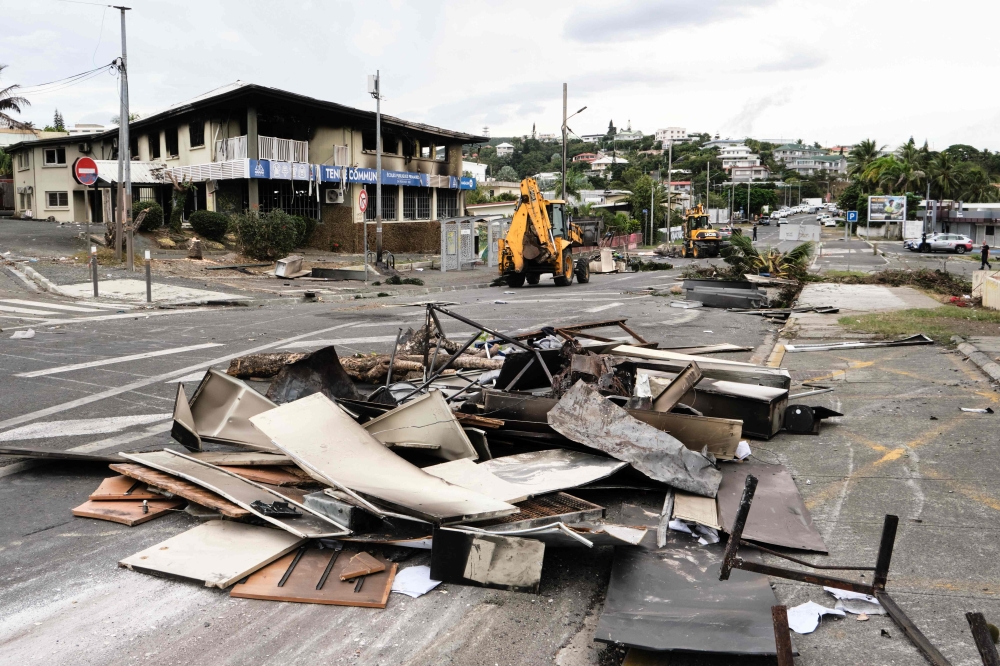 Operations in place to remove roadblock barricades, two weeks after deadly riots broke out in Noumea. — AFP pic