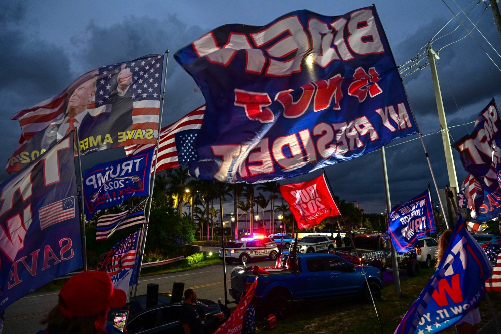 Supporters of former US President Donald Trump hold signs and flags as they show their support for the Republican 2024 presidential candidate during a 