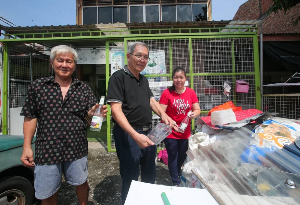 (From left) Koperasi Rejuvinasi Malaysia Berhad (Korem) caretaker Ng Chor Choon, directors Victor Chew and Michelle Siew showing the bottles collected at their Pasir Pinji hub. — Picture by Farhan Najib