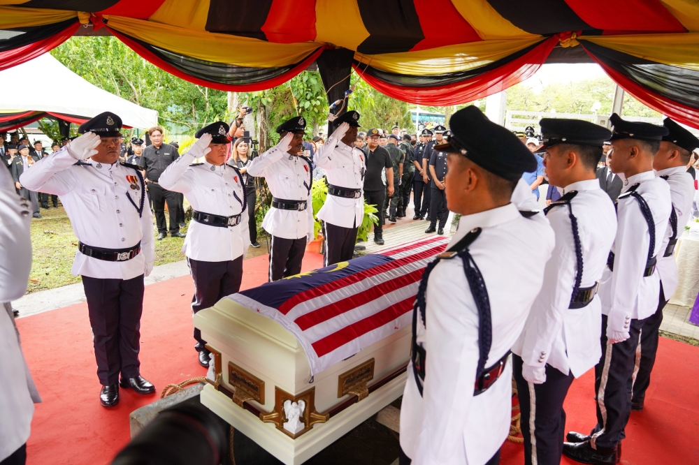 Pallbearers salute Etin’s coffin prior to the committal service at the Heroes’ Grave. ― The Borneo Post pic