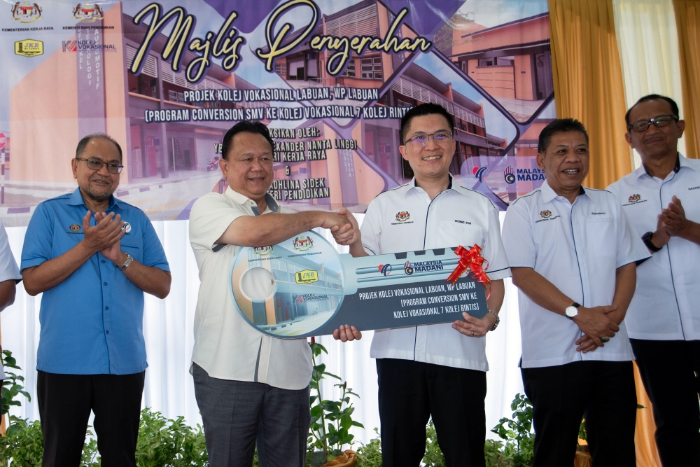 Works Minister Datuk Seri Alexander Nanta Linggi hands over a replica key to Deputy Eduation Minister Wong Kah Woh at the handover ceremony of the Labuan Vocational College Project in Labuan, June 7, 2024. — Bernama pic 
