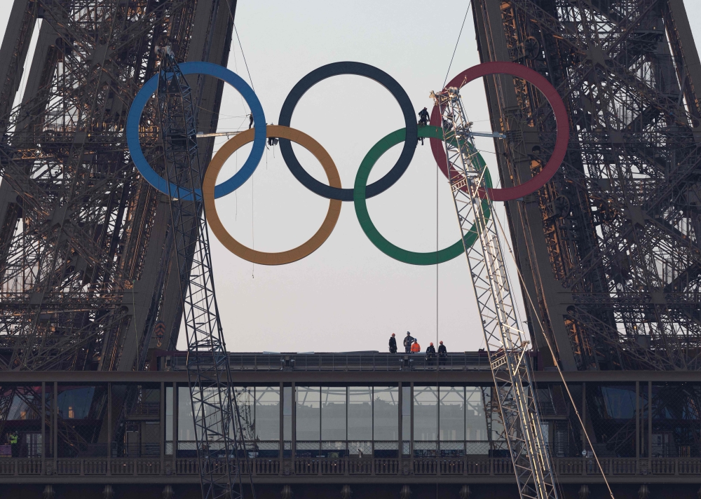 The Olympic rings are seen on the Eiffel Tower before an unveiling ceremony in Paris, early on June 7, 2024, ahead the upcoming Paris 2024 Olympic Games. — AFP pic 
