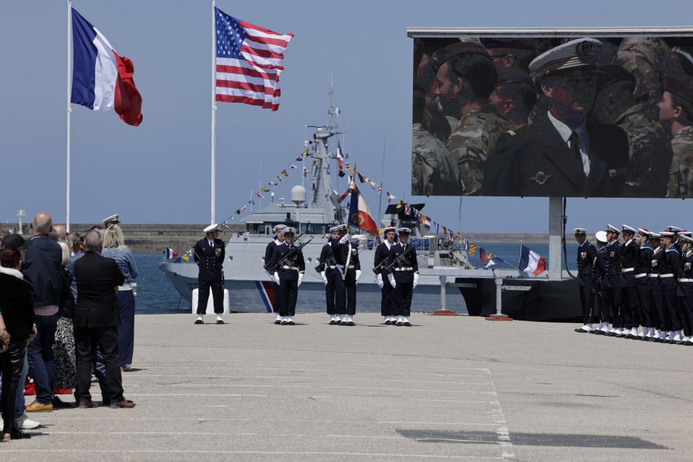 The French and the US flags fly during a commemorative ceremony in the city of Cherbourg, France June 7, 2024. ― Andre Pain/Pool via Reuters
