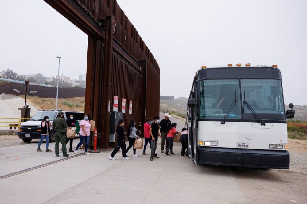 US Border Patrol agents use a bus to transport migrants who overnight gathered between the primary and secondary border walls that separate Mexico and the United States, after tough new restrictions imposed by US President Biden in San Diego, California, US, June 6, 2024. — Reuters pic