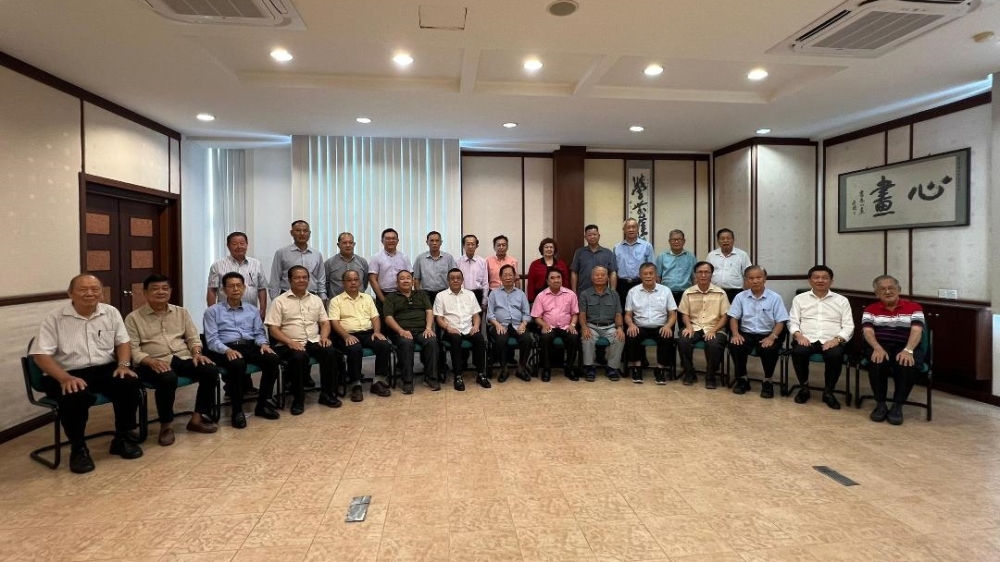 Lau (seated eighth left) with the board of directors pose after the AGM. — The Borneo Post pic