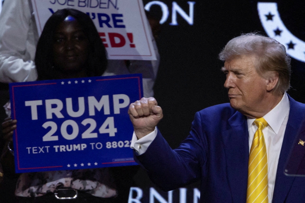  Republican presidential candidate and former US president Donald Trump gestures as a supporter looks on during a Turning Point USA event at the Dream City Church in Phoenix, Arizona June 6, 2024. — Reuters pic  