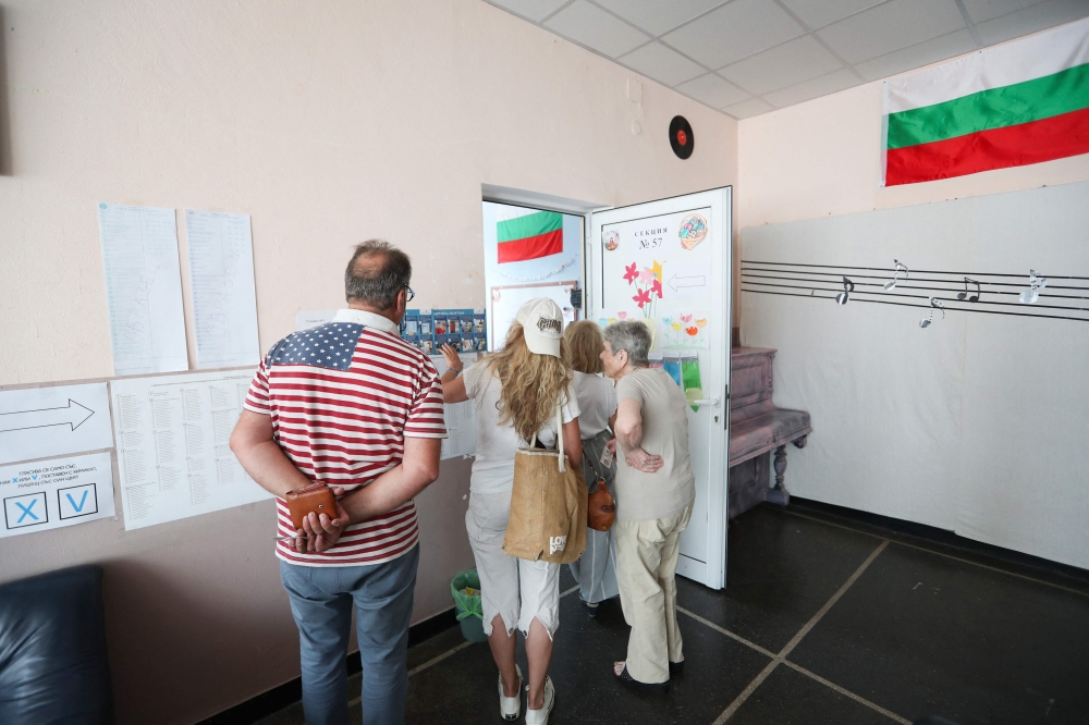 People wait at a polling station to vote during parliamentary and European Parliament elections at a polling station in Sofia June 9, 2024. — AFP pic