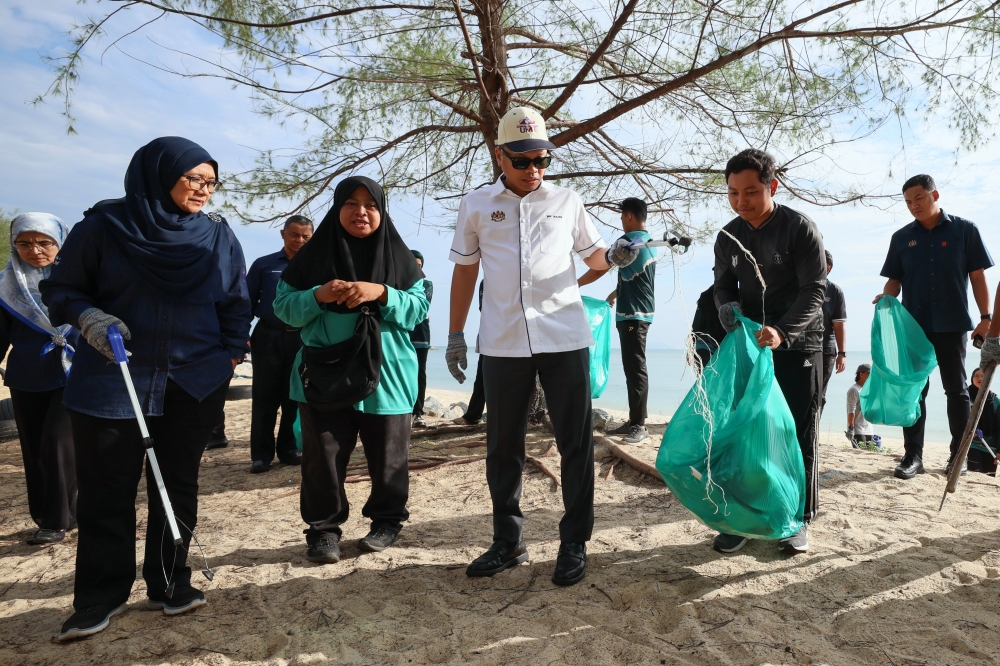 Natural Resources and Environmental Sustainability Minister Nik Nazmi Nik Ahmad picks up rubbish on the beach during the launch of World Oceans Week in conjunction with the Environmental Sustainability Tour at Universiti Malaysia Terengganu, June 10, 2024. — Bernama pic 