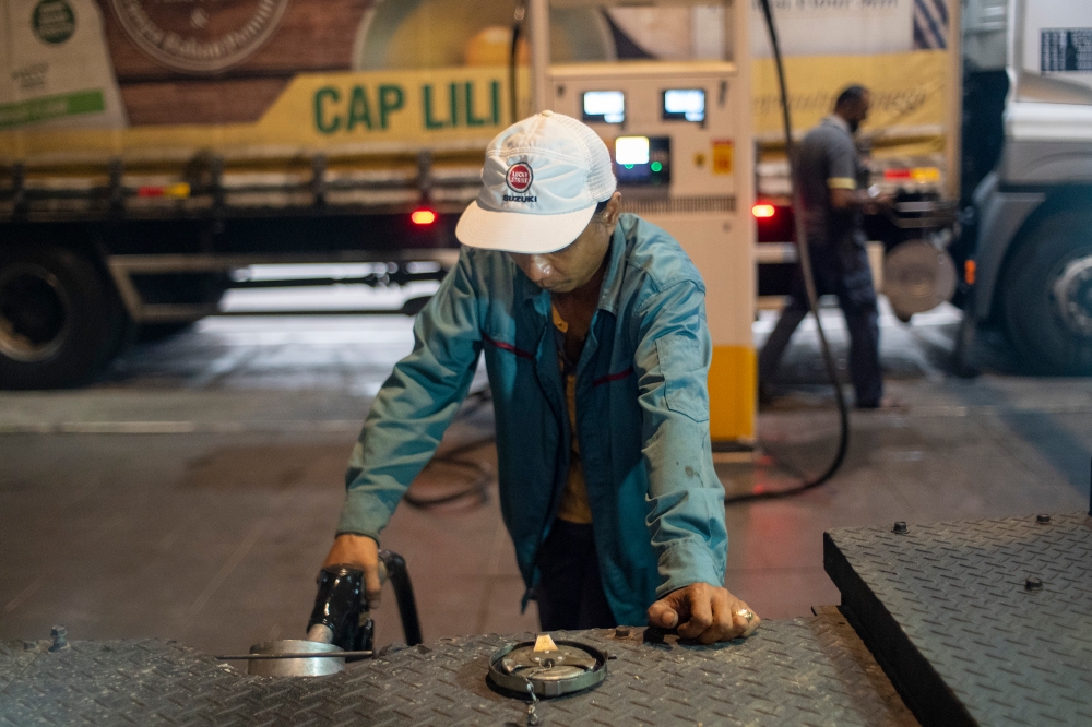 Workers refuelling diesel at a gas station in Telok Panglima Garang on June 9, 2024. — Picture by Shafwan Zaidon