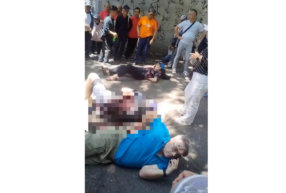 People gather around four American educators from an Iowa university, who were reportedly stabbed in a public park, according to the US media and US government officials, in Jilin City, Jilin province, China, in this still image taken from a video obtained by Reuters and released on June 10, 2024. — Video obtained by Reuters