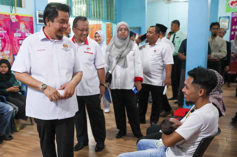 Deputy Health Minister Datuk Lukanisman Awang Sauni speaks to patients seek at the Mother and Child Health Clinic in Pekan, June 11, 2024. — Bernama pic 