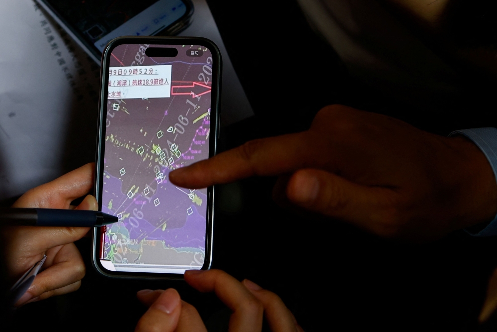 Coast guard Administration Deputy Director Cheng Cing-cin points at a spot on a map where a former Chinese navy captain's speedboat entered the Taipei harbour to members of the media at a press conference in Taipei June 11, 2024. — Reuters pic  