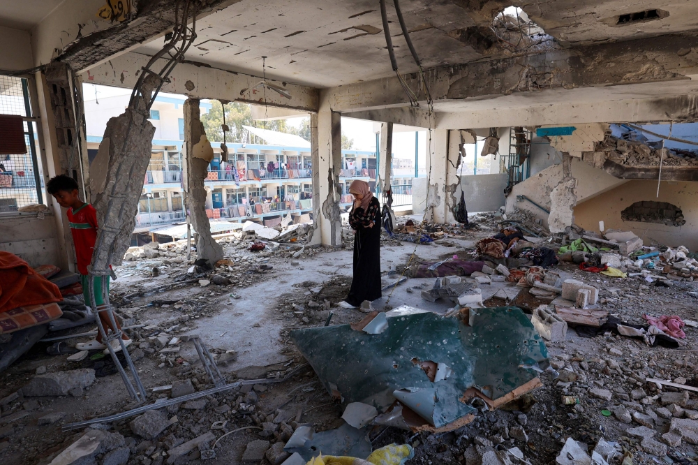 A Palestinian woman stands in the middle of a destroyed classroom at a school run by the UN Relief and Works Agency for Palestine Refugees (UNRWA) which was hit during an Israeli army strike the day before, in the Nuseirat camp in the central Gaza Strip on June 7, 2024, amid the ongoing conflict in the Palestinian territory between Israel and Hamas. — AFP pic