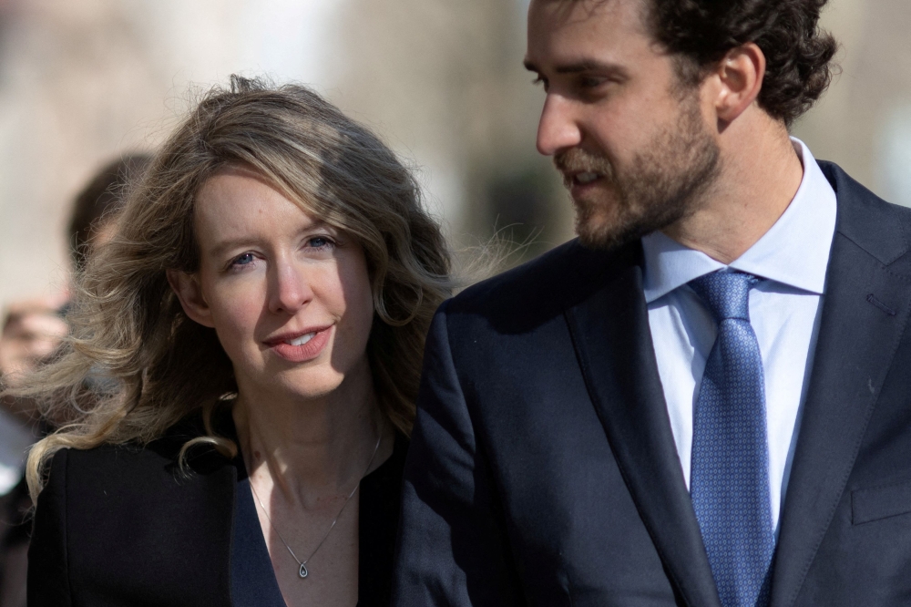 Theranos founder Elizabeth Holmes arrives at the federal courthouse accompanied by her partner Billy Evans, to ask a US judge at a hearing to pause her prison sentence of more than 11 years while she urges an appeals court to review her conviction on charges of defrauding investors in the blood testing startup at the federal courthouse in San Jose, California March 17, 2023. — Reuters file pic