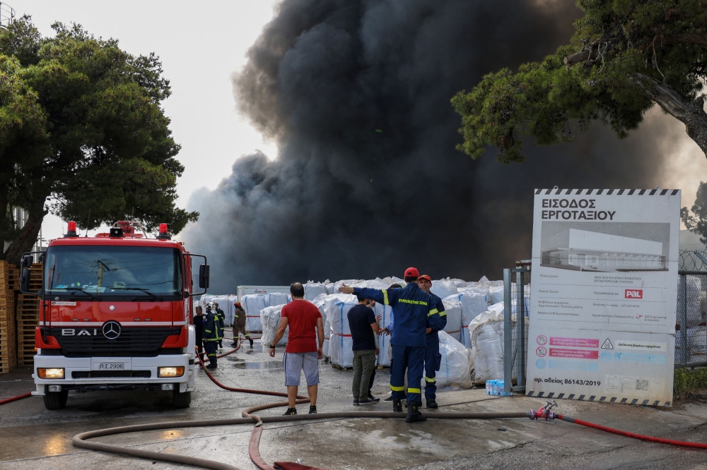 Dozens of firefighters were battling a blaze at a cookware factory in Athens today that sent thick plumes of black smoke into the air, the fire service said. — Reuters pic