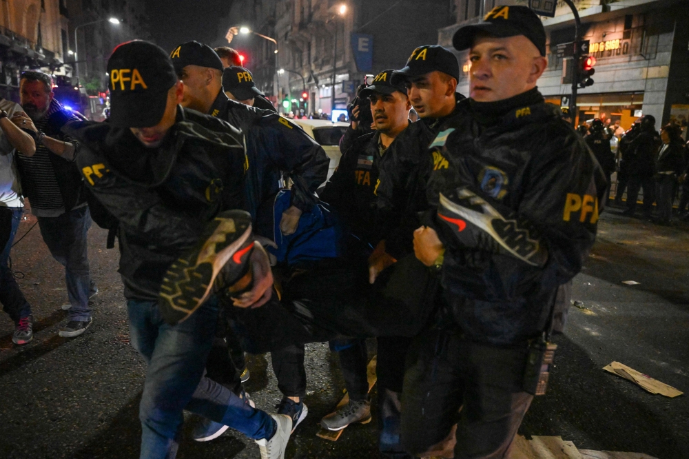 Police officers detaining demonstrators during a protest outside the National Congress in Buenos Aires. — AFP pic