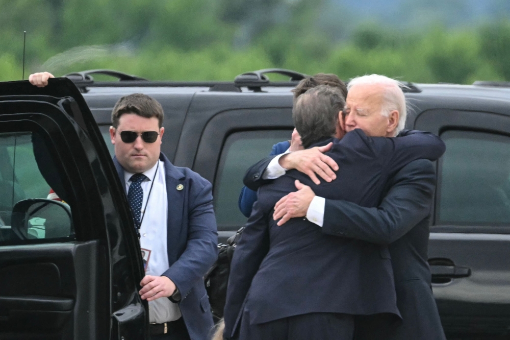 US President Joe Biden hugs his son Hunter Biden upon arrival at Delaware Air National Guard Base. — AFP pic