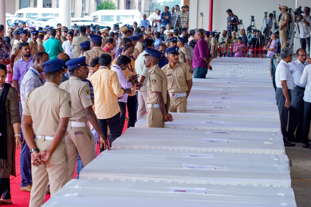 Grieving families kept a solemn vigil in the terminal of an Indian airport today as the bodies of dozens of migrant workers killed in a Kuwait building fire returned home. — AFP pic