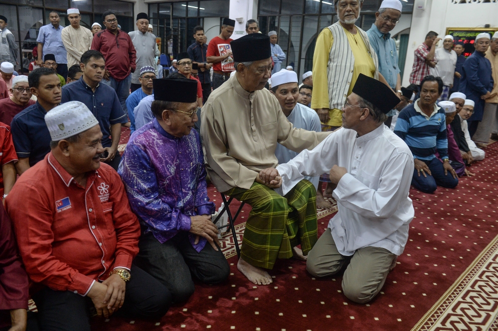 File picture of Datuk Seri Anwar Ibrahim and Tan Sri Muhyiddin Yassin during a special prayer at Bagan Pinang mosque in Port Dickson, October 11, 2018. Anwar and Muhyiddin announced today that they have agreed to cease their ongoing defamation lawsuits against each other. — Picture by Yusof Mat Isa