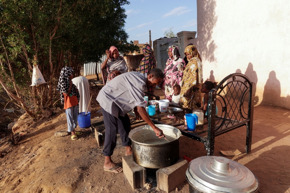 Displaced Sudanese families wait to receive food from a charity kitchen in the city of Omdurman, Sudan, April 6, 2024. — Reuters pic  