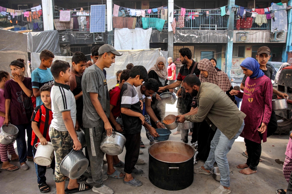 Children queue with pots to receive food aid from a kitchen at the Abu Zeitun school run by the UN Relief and Works Agency for Palestine Refugees (UNRWA) in the Jabalia camp for Palestinian refugees in the northern Gaza Strip on June 13, 2024 amid the ongoing conflict in the Palestinian territory between Israel and Hamas. — AFP pic