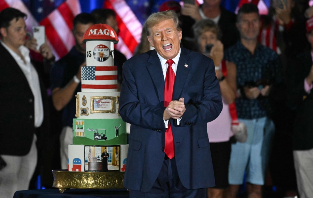Former US President and Republican presidential candidate Donald Trump gestures by his birthday cake, created by Club 47, during a campaign rally as he celebrates his 78th birthday at West Palm Convention Center, in West Palm Beach, Florida June 14, 2024. — AFP pic