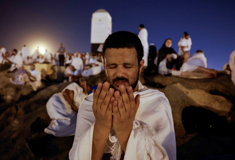 A Muslim pilgrim prays at Mount of Mercy on the plain of Arafat during the annual haj pilgrimage, outside the holy city of Mecca, Saudi Arabia June 15, 2024. — Reuters pic