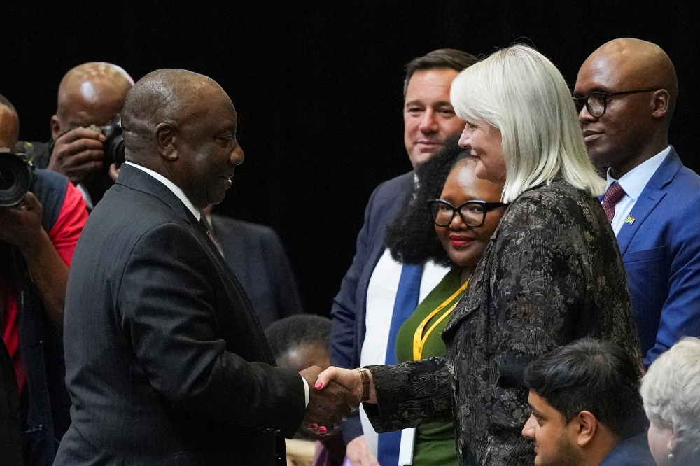 South African president Cyril Ramaphosa (left) shakes hands with the newly elected Deputy Speaker of Parliament Annelie Lotriet (right) whilst leader of the opposition Democratic Alliance (DA) John Steenhuisen (centre) looks on, during the first sitting of the National Assembly following elections at the Cape Town International Convention Center (CTICC) in Cape Town, South Africa June 14, 2024. — Reuters pic