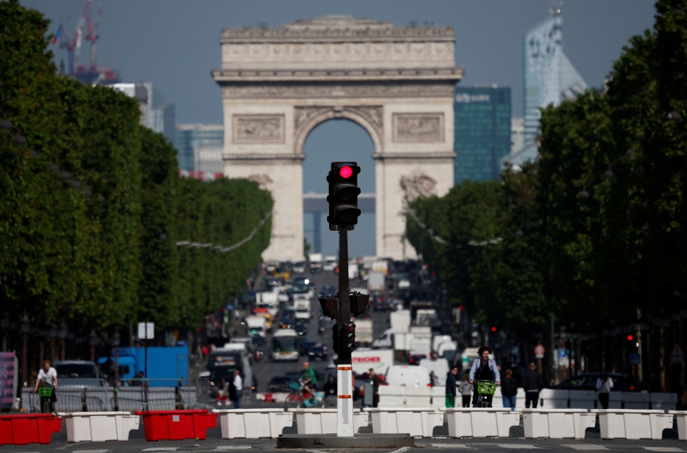 File photo of traffic light shining red on the Champs-Elysees avenue with the Arc de Triomphe in the background in Paris, France, June 13, 2024. — Reuters pic