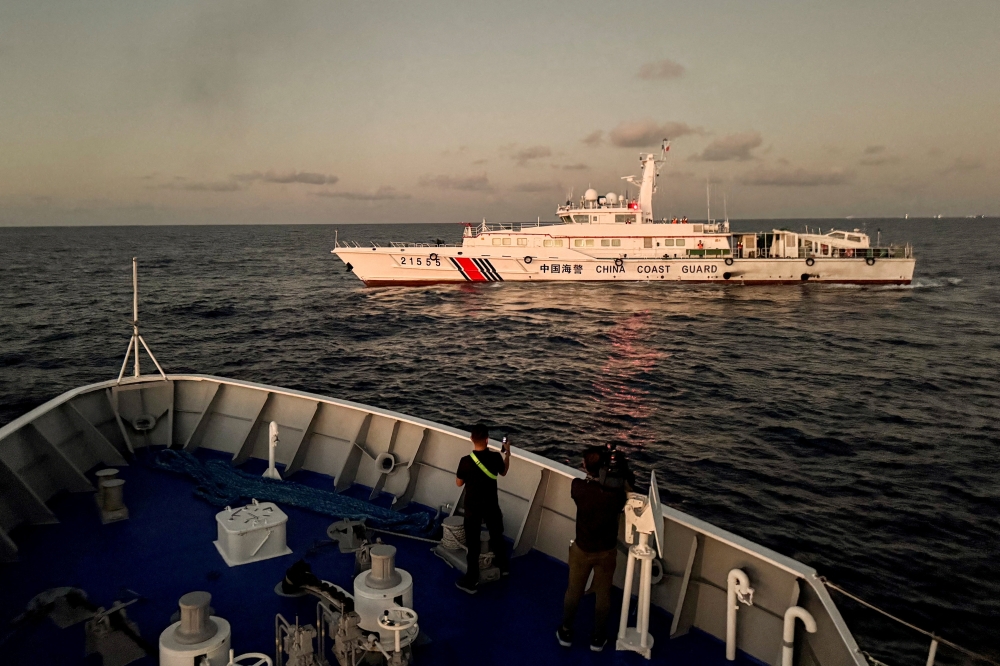 File photo of members of the media taking footage of a Chinese Coast Guard vessel blocking a Philippine Coast Guard vessel on its way to a resupply mission at Second Thomas Shoal in the South China Sea, March 5, 2024. — Reuters pic