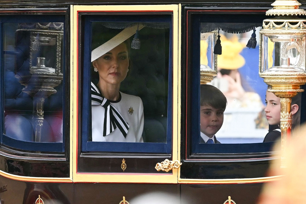 Britain’s Catherine, Princess of Wales, sits with Britain's Princess Charlotte of Wales (right) and Britain’s Prince Louis of Wales (centre) inside the Glass State Coach on their way to Horse Guards Parade for the King’s Birthday Parade ‘Trooping the Colour’ in London on June 15, 2024. — Reuters pic