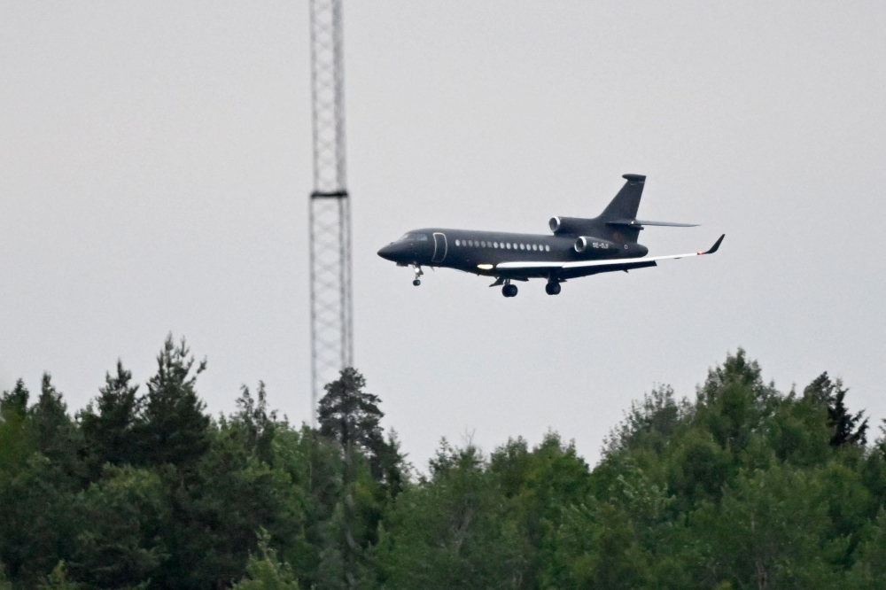 An airplane believed to be carrying Swedish EU diplomat Johan Floderus and Swedish national Saeed Azizi approaches Arlanda Airport in Stockholm, Sweden. — AFP pic