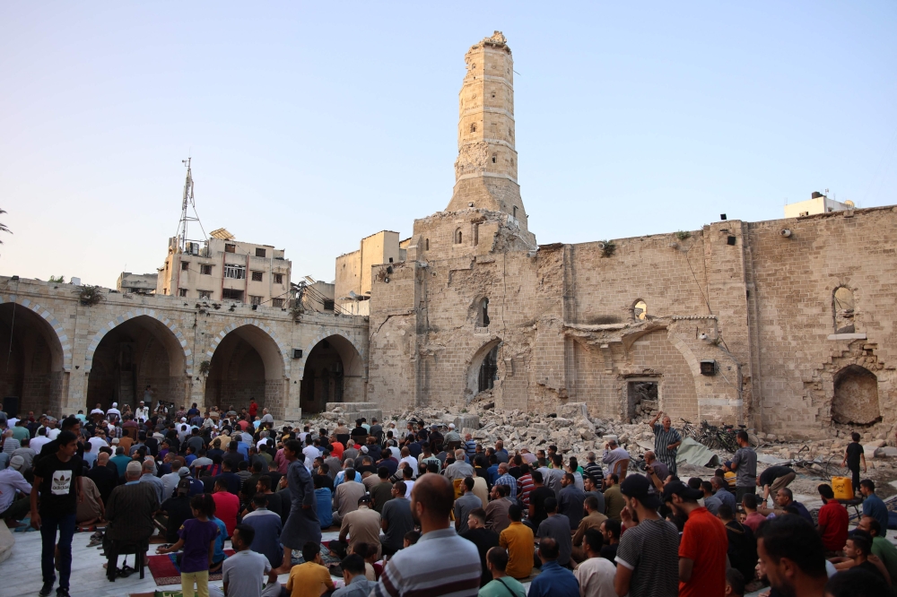Palestinians perform the Aidiladha morning prayer in the courtyard of Gaza City’s historic Omari Mosque, which was heavily damaged in Israeli bombardment. — AFP pic