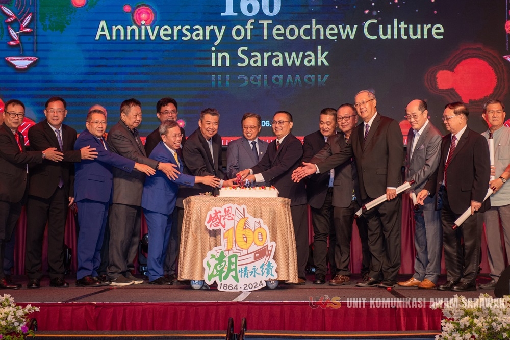 Abang Johari (eighth right) seen on the stage cutting the anniversary cake during the event. Also seen is Dr Sim (fifth, left) and others. — The Borneo Post pic