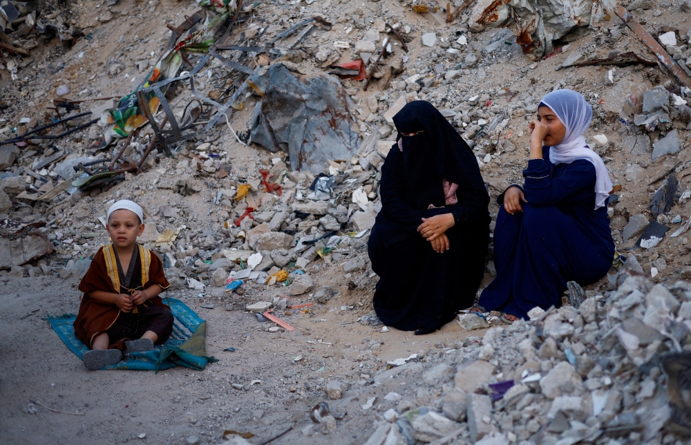 Palestinians attend Eid al-Adha prayers by the ruins of al-Al Rahma mosque destroyed by Israeli air strikes, amid the Israel-Hamas conflict, in Khan Younis, in the southern Gaza Strip, June 16, 2024. — Reuters pic