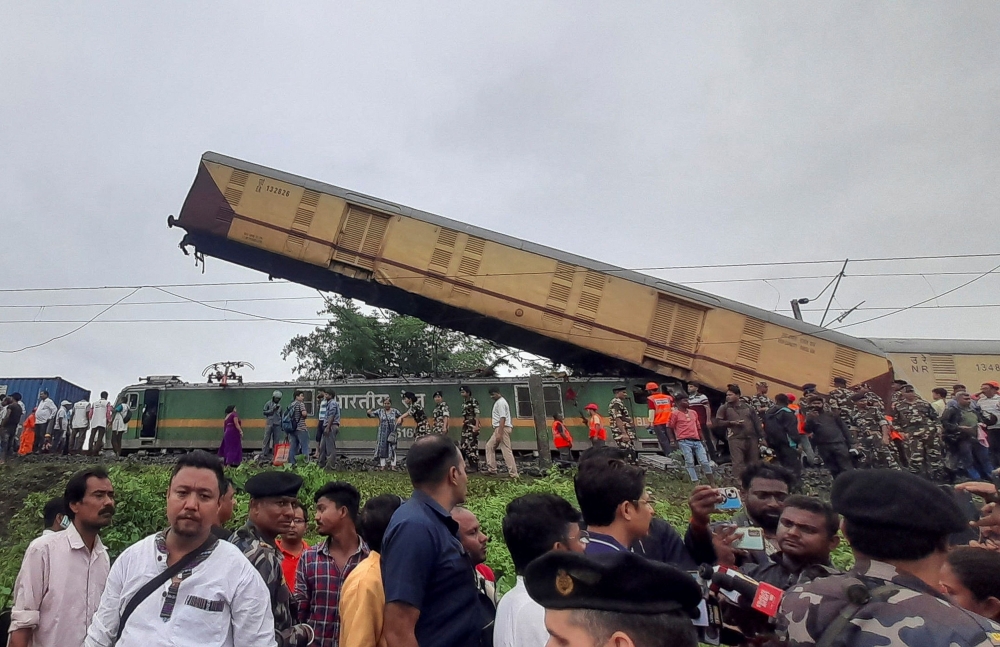 Rescue workers along with people gather at the site of a train collision after the accident in Darjeeling district in West Bengal state, India June 17, 2024. — Reuters pic