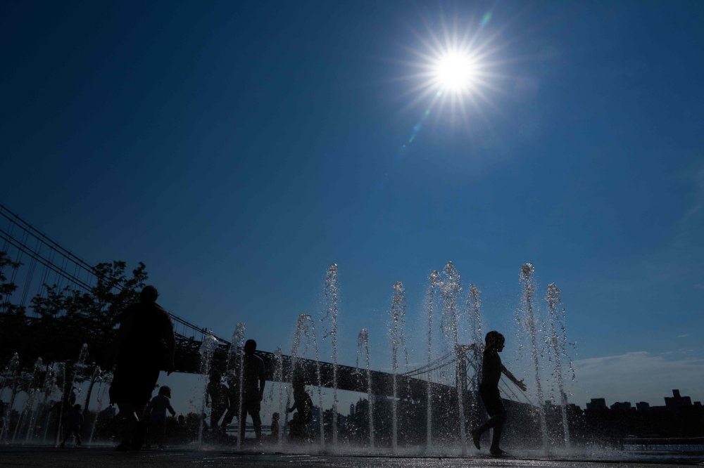 People play in a water fountain in Domino Park in Brooklyn, New York, as a heat wave hits the northeast US on June 18, 2024. — AFP pic