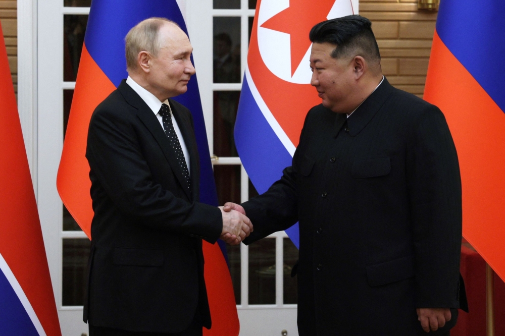  In this pool photograph distributed by the Russian state agency Sputnik, North Korea's leader Kim Jong-un  and and Russian President Vladimir Putin shake hands after a welcoming ceremony at Kim Il Sung Square in Pyongyang on June 19, 2024. — Gavriil Grigorov / Pool / AFP pic