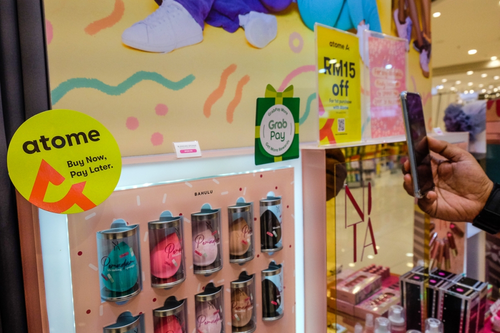 File picture of a customer scanning a QR code for the Atome app to make a cashless payment at a shop in Shah Alam, June 23, 2022. The initial scrum for market share also appears to have settled, with three BNPL providers — Shopee, Grab, and Atome — now dominating the market and accounting for 97 per cent of total transactions and 96 per cent of value in the first three quarters of 2023. — Picture by Yusof Mat Isa