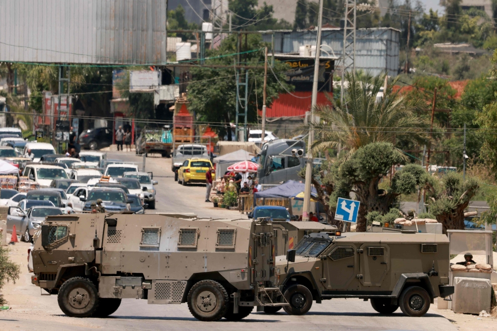 Israeli army vehicles close off the entrance to the West Bank city of Qalqilya after an Israeli civilian was shot and killed on June 22, 2024, amid the ongoing conflict between Israel and Hamas in the Gaza Strip. — AFP pic