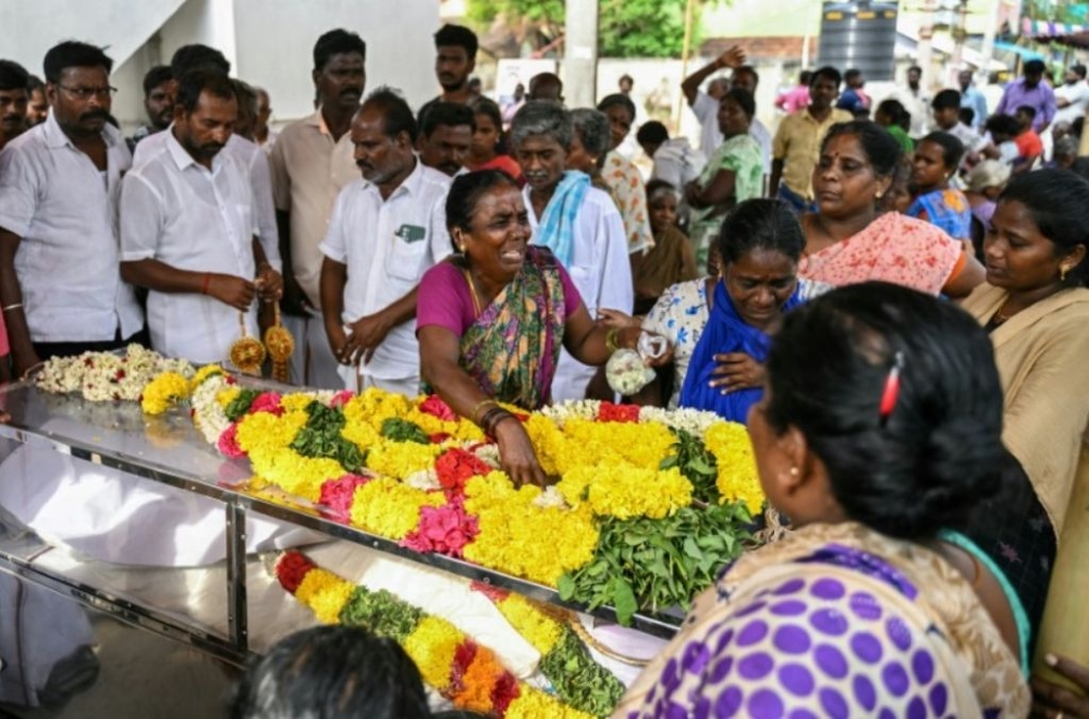 A relative weeps next to the dead body of a victim who died after consuming toxic illegal alcohol in Kallakurichi district of India’s Tamil Nadu state. — AFP pic