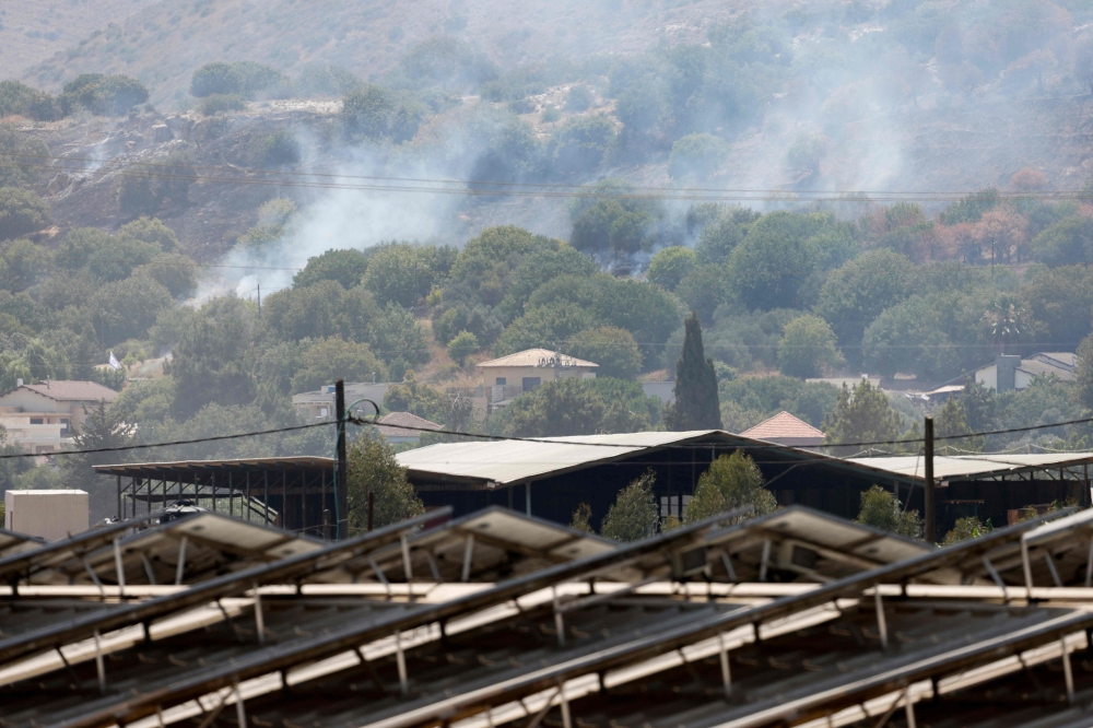 Smoke plumes rise from a fire in a field after a drone launched from southern Lebanon landed near Moshav Dishon in the Upper Galilee near the Lebanese border on June 23, 2024. — AFP pic